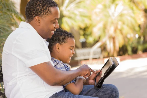 Gemengd ras vader en zoon met behulp van de tablet van de computer van het stootkussen van de aanraking — Stockfoto