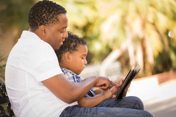 Padre e hijo de raza mixta usando tableta de computadora Touch Pad —  Fotos de Stock