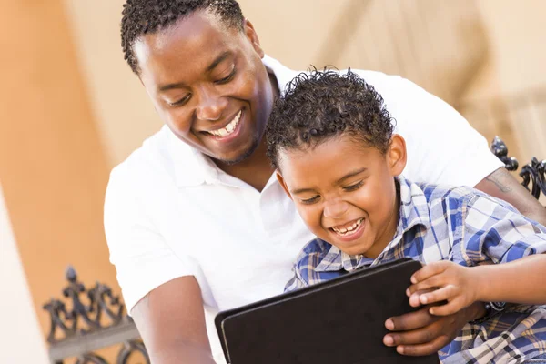 Padre e hijo de raza mixta usando tableta de computadora Touch Pad —  Fotos de Stock