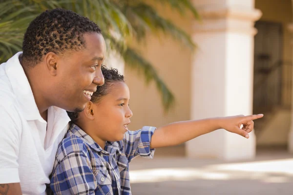 Padre e hijo de raza mixta señalando en el parque — Foto de Stock