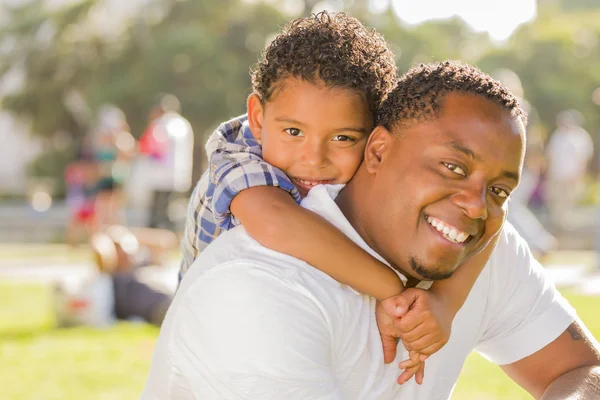 Karışık ırk baba ve oğul sırtıma parkta oynarken — Stok fotoğraf