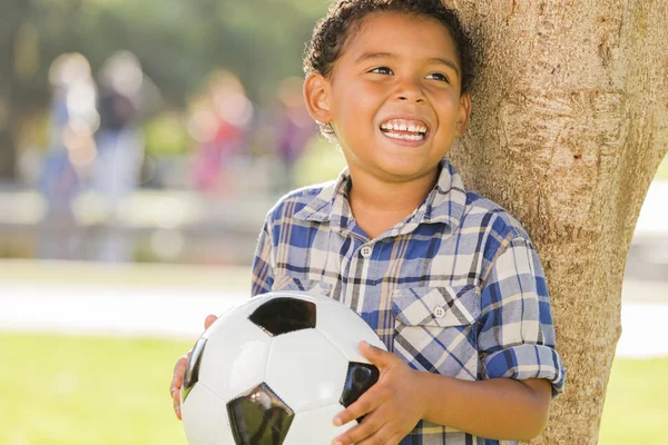 Μικτή φυλή αγόρι, κρατώντας την μπάλα ποδοσφαίρου στο πάρκο — Φωτογραφία Αρχείου