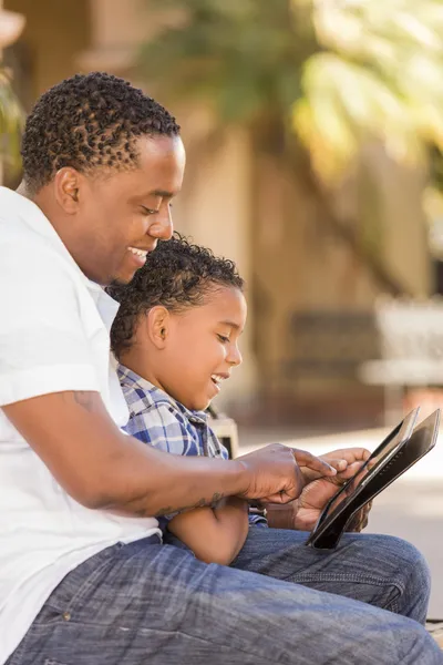 Karışık ırk baba ve oğul dokunmatik yüzey bilgisayar tablet kullanma — Stok fotoğraf