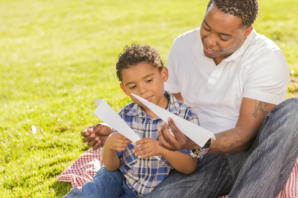 Karışık ırk baba ve oğul kağıt uçaklar ile oynama — Stok fotoğraf
