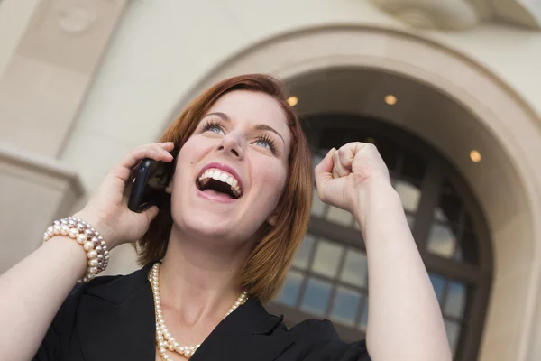 Ung affärskvinna med näven i luften på mobiltelefon — Stockfoto