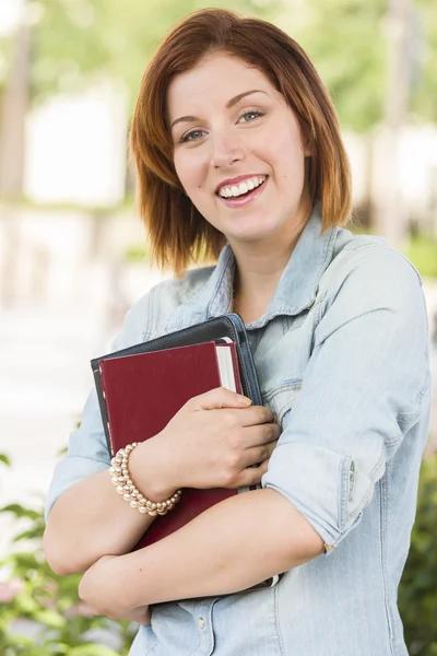 Lächelnde junge Studentin draußen mit Büchern — Stockfoto