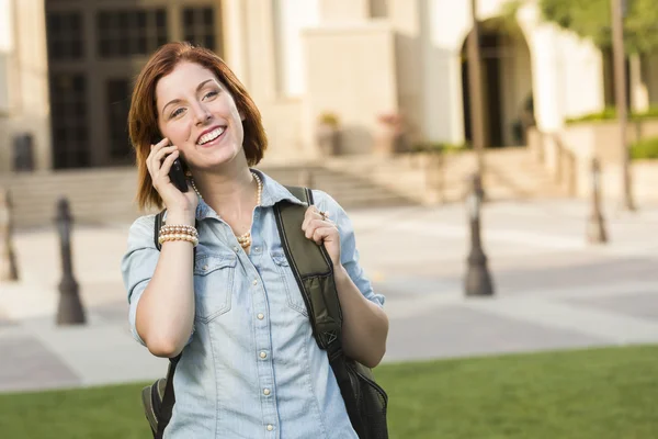 Jonge vrouwelijke student lopen buiten het gebruik van mobiele telefoon — Stockfoto