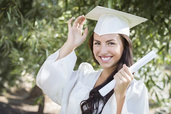 Випускниця змішаної гонки Дівчина в шапці і сукні з дипломом — стокове фото