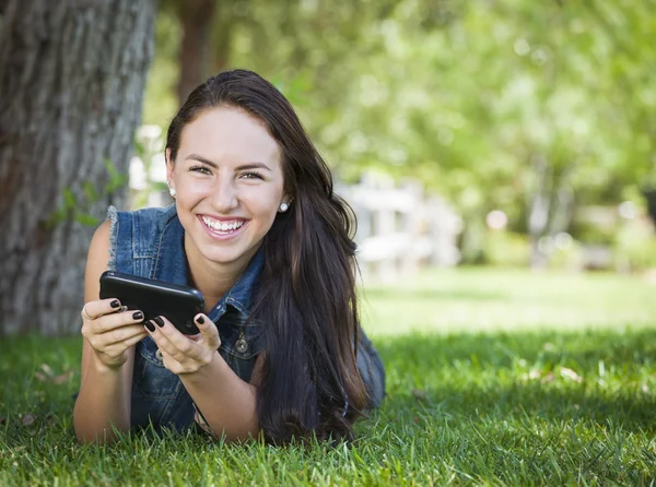 Blandras unga kvinnliga skicka SMS på mobilen utanför — Stockfoto