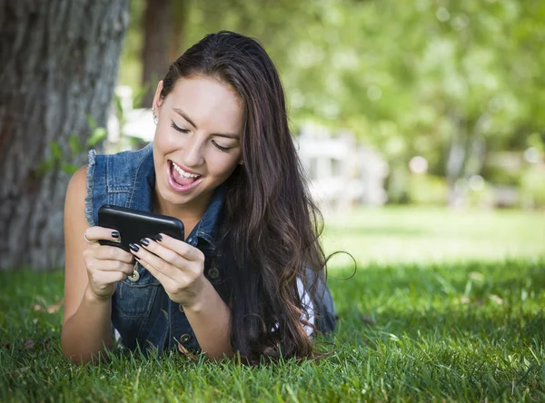 Gemengd ras jonge vrouwelijke texting op mobiele telefoon buiten — Stockfoto