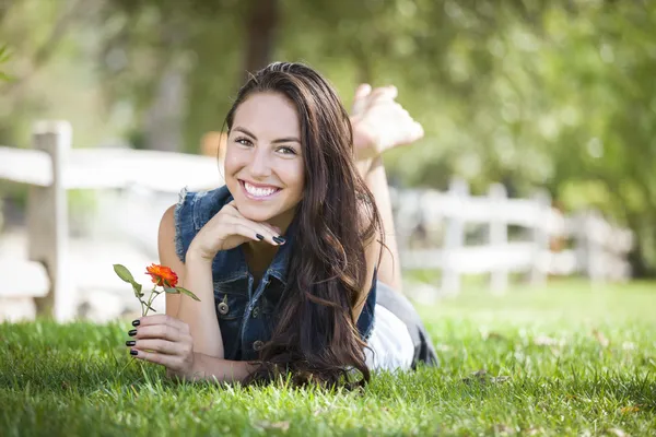 Aantrekkelijke gemengd ras meisje portret leggen in gras — Stockfoto