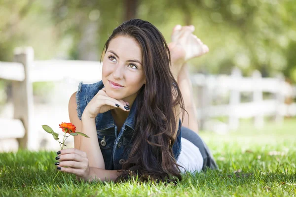 Aantrekkelijke gemengd ras meisje portret leggen in gras — Stockfoto