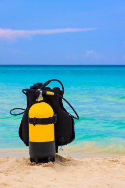 Scuba diving equipment on a beach clipart