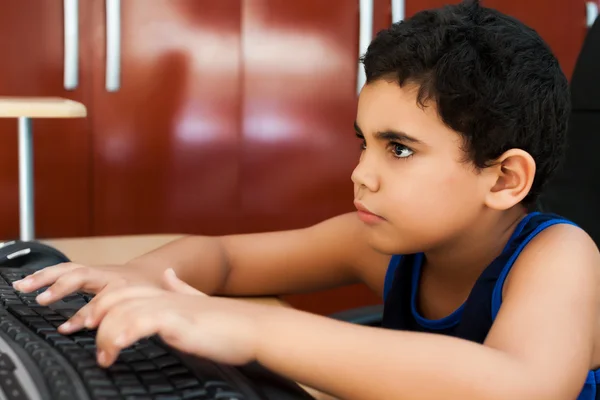 可爱的西班牙裔男孩在一台计算机上键入 — 图库照片