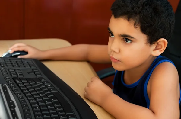 Kleine Latijns-jongen op een computer werkt — Stockfoto