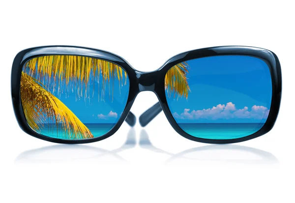 Sunglasses with a beach scene reflected on the glass — Stock Photo, Image