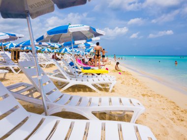 Tourists sunbathing at a cuban beach clipart