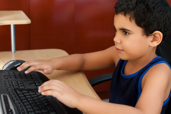 Bambino ispanico che lavora con un computer — Foto Stock