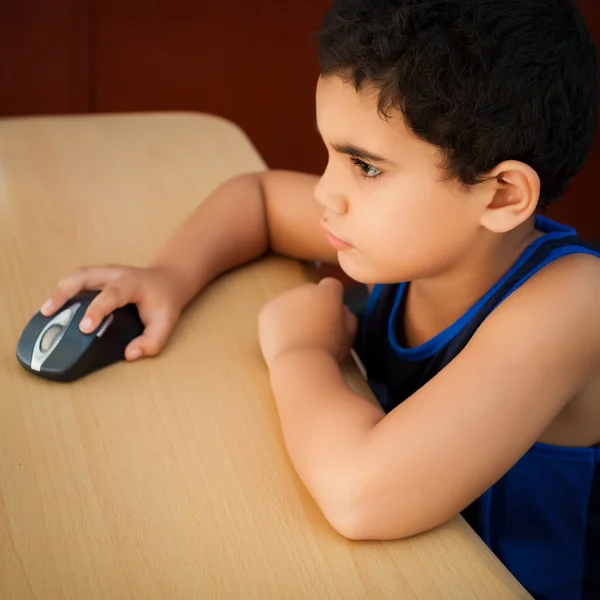 Criança hispânica trabalhando com um computador — Fotografia de Stock