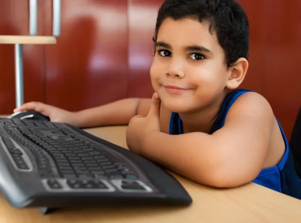 Niño hispano trabajando con una computadora — Foto de Stock