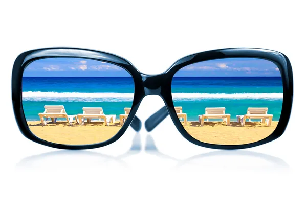 Gafas de sol con una playa reflejada en ellas — Foto de Stock