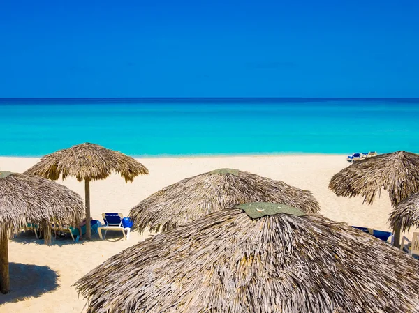 Parasole kryte strzechą na plaży na Kubie — Zdjęcie stockowe