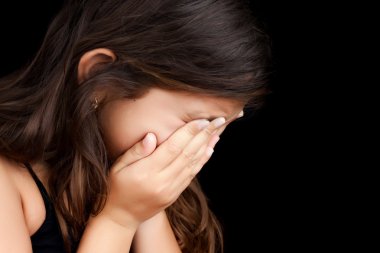 Portrait of a girl crying and hiding her face clipart