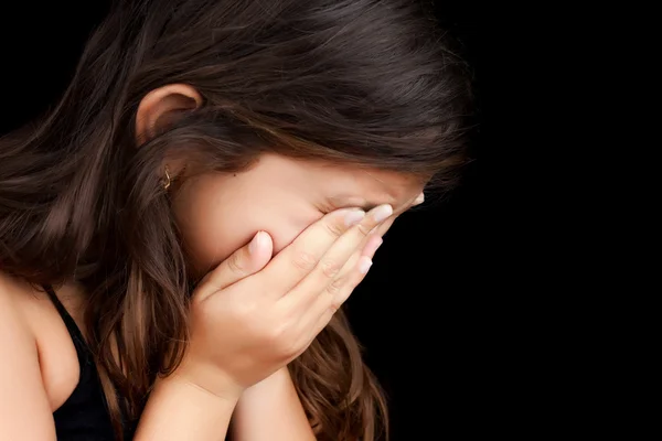 Porträt eines Mädchens, das weint und ihr Gesicht versteckt lizenzfreie Stockbilder