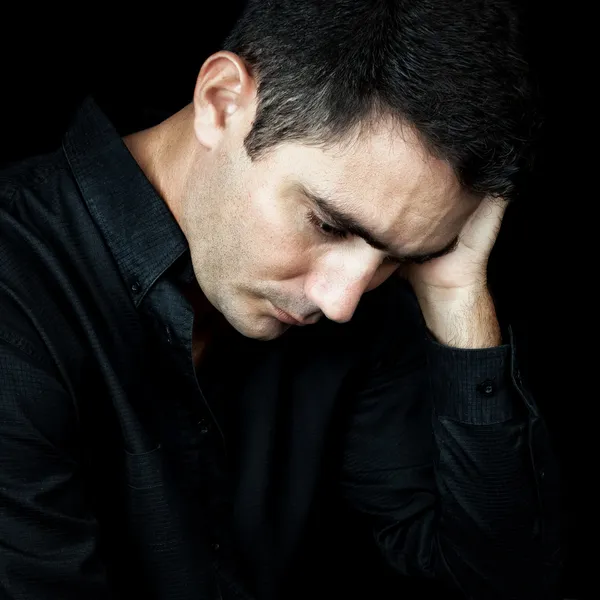 Hombre preocupado y deprimido aislado en negro —  Fotos de Stock