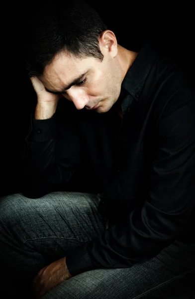 Preoccupato e depresso uomo isolato su nero — Foto Stock