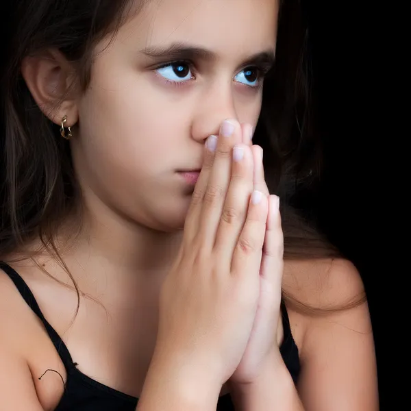 Hispanic meisje bidden geïsoleerd op zwart — Stockfoto