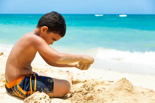 Niño hispano construyendo un castillo de arena — Foto de Stock