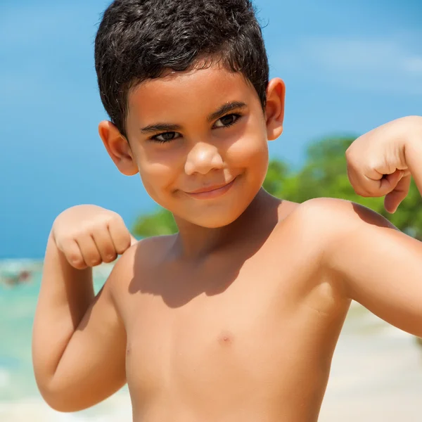 Criança hispânica mostrando seus músculos — Fotografia de Stock