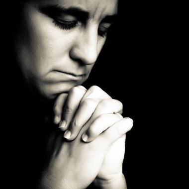 Woman praying isolated on black clipart