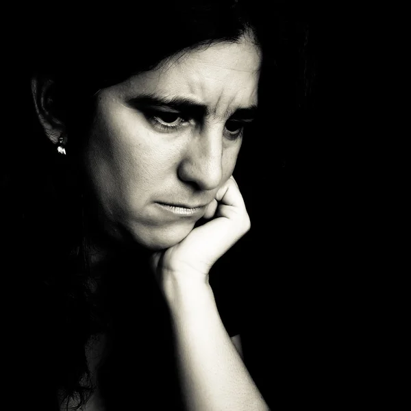 Беспокойная женщина на черном фоне — стоковое фото