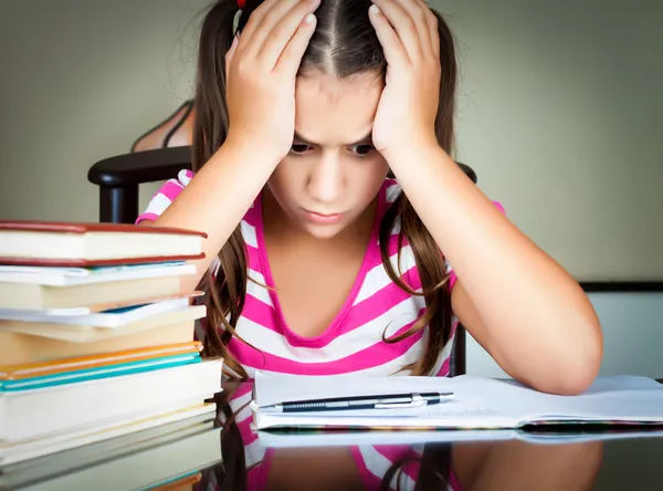 Angry and tired schoolgirl studying — Stock Photo, Image