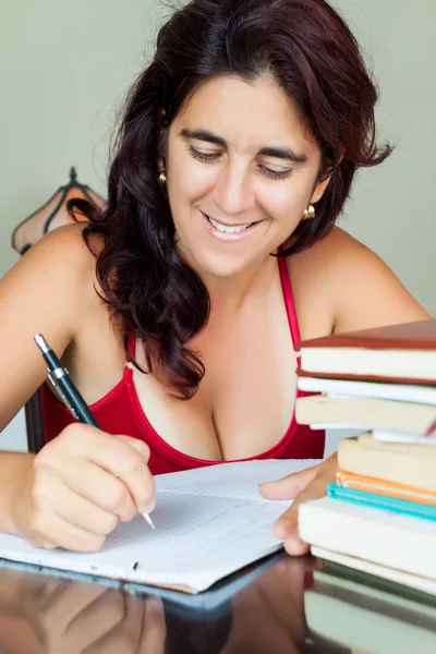 Hispanische Frau schreibt in ein Notizbuch — Stockfoto