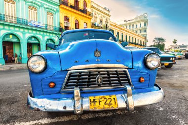 Old american car in a colorful neighborhood in Havana clipart