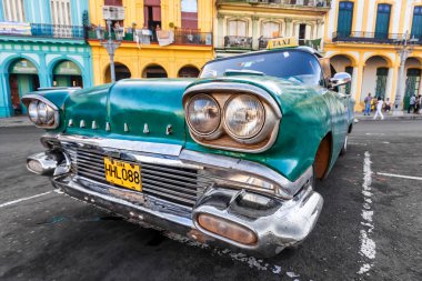 Classic Cadillac in a colorful neighborhood in Havana clipart