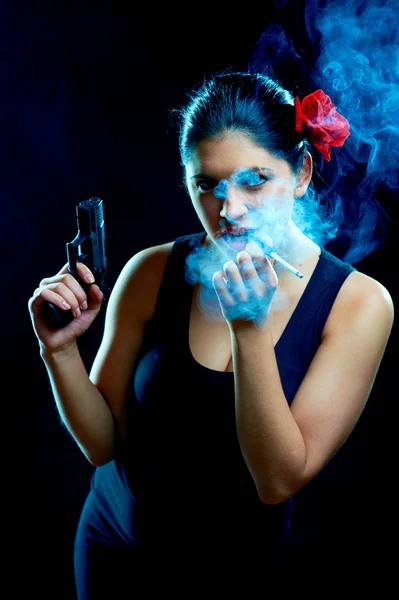 Charming spanish women with cigarette and gun — Stock Photo, Image