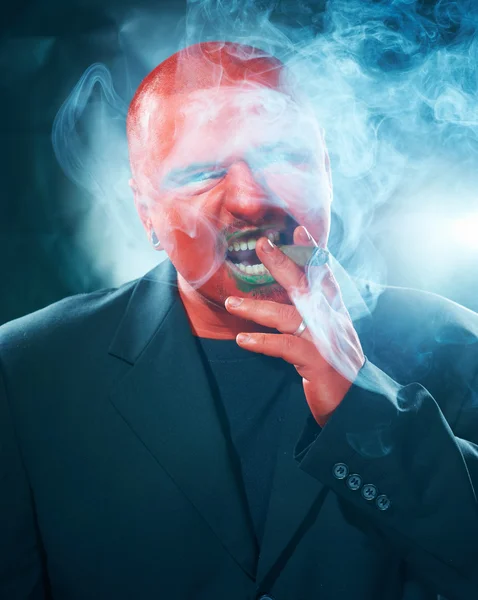 Hombre misterioso con cara roja fumando cigarro . — Foto de Stock