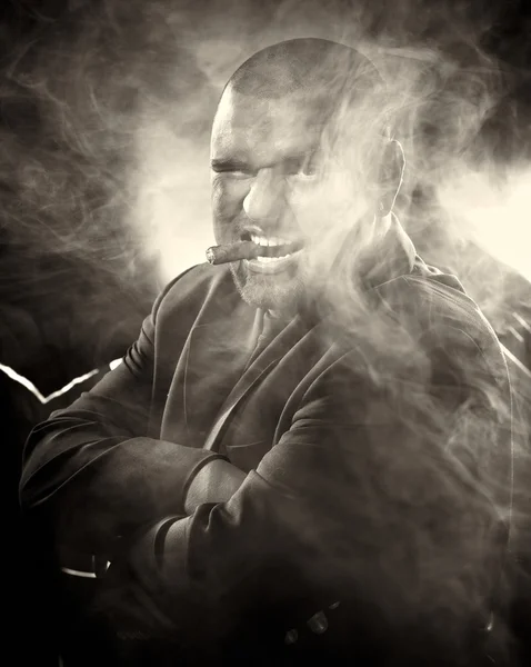 Niebezpieczny człowiek z straszne twarz palenia cygar. — Zdjęcie stockowe