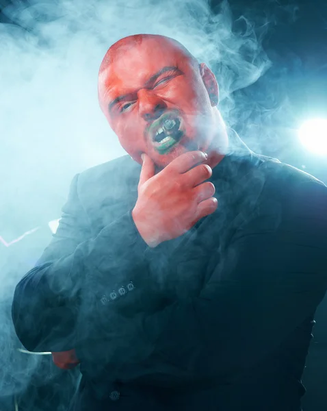 Homem misterioso com cara vermelha fumar charuto . — Fotografia de Stock