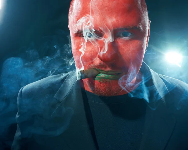 Arg man med rött ansikte röka cigarr. — Stockfoto