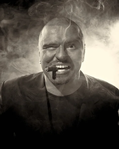 Nebezpečný muž s strašidelné obličeje kouření doutníku. — Stock fotografie