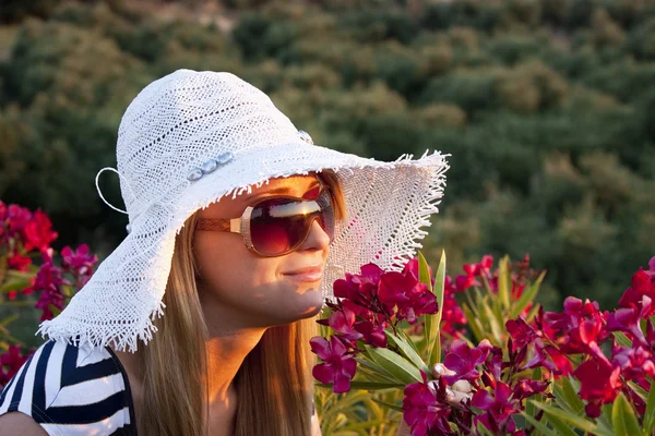Junge blonde Frau, die Blumen riecht — Stockfoto