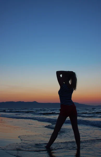 Silhuetten av en kvinna på en strand — Stockfoto