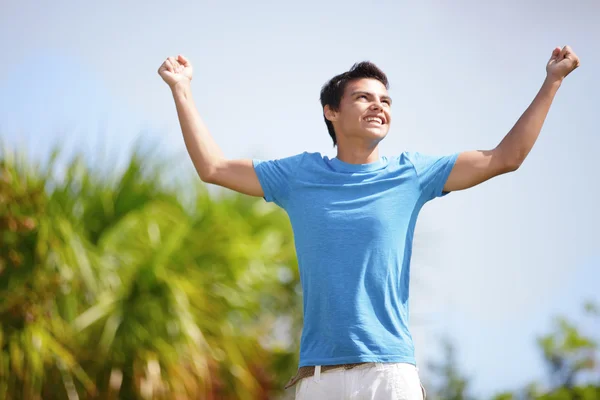 Young male in the park with hands up — Stock Photo, Image