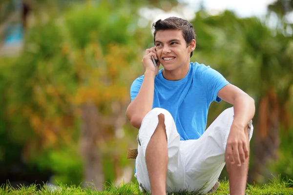 Молодой мужчина с мобильным телефоном в парке — стоковое фото