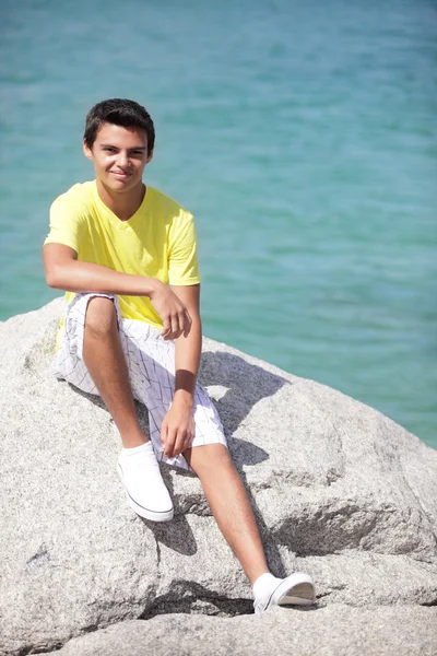 Suyun kenarında oturan genç erkek — Stok fotoğraf